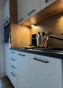 SchönwaldBlack Forest Home的厨房配有白色橱柜和炉灶烤箱。