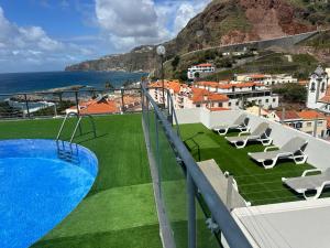 里韦拉布拉瓦Flag Hotel Madeira - Ribeira Brava的一个带游泳池和椅子的阳台,享有海景