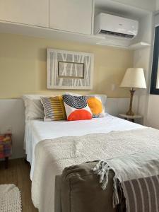 圣保罗Is Liberdade的卧室配有白色的床和色彩缤纷的枕头