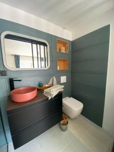 安格雷COSY ROOM PRIVATE BATH AND GARDEN的一间带红色盥洗盆和卫生间的浴室