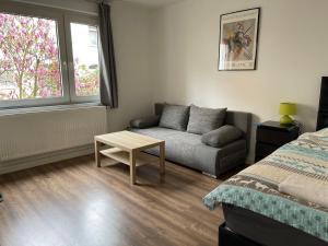 杜伊斯堡near Düsseldorf Messe and Airport, two Bedrooms, Parking, Kitchen and Garden的一间卧室配有一张床、一张沙发和一张桌子