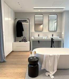 雅典AIONION RESIDENCES by K&K的带浴缸、两个盥洗盆和镜子的浴室