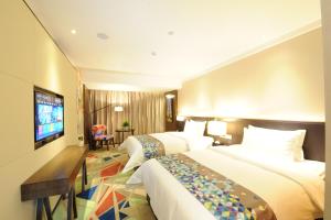 广州潮漫酒店（广州火车站三元里地铁站店）的酒店客房设有两张床和一台平面电视。