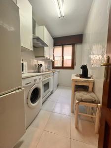 雷凯蒂奥Apartamento en la costa的厨房配有洗衣机和桌子