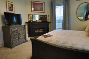 加利纳Cloran Mansion Bed & Breakfast的一间卧室配有一张床、一台电视和一面镜子
