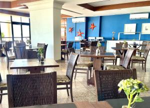 福塔莱萨Aconchego à Beira Mar (no melhor do Meireles)的餐厅设有木桌和椅子,拥有蓝色的墙壁