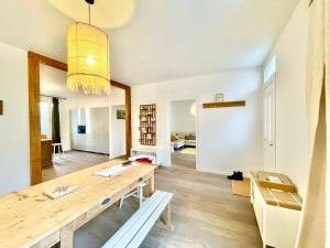 圣纳泽尔La Villa Billard - 200 m2 - Jardin的一间带木桌的房间和一间用餐室