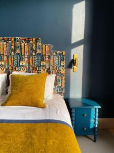 凯西克Fellpack House的一张带色彩缤纷床头板和蓝色桌子的床
