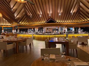 丹格迪Amaya Kuda Rah的餐厅设有木制天花板和桌椅