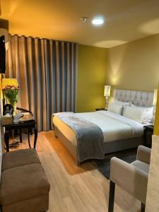 布拉干萨郁金香酒店的一间卧室配有一张特大号床和一张沙发