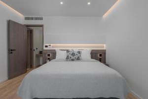 帕诺尔莫斯斯科派洛斯Adrina Grand Hotel的卧室配有一张带枕头的大型白色床