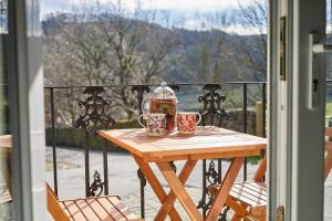 GreetlandHost & Stay - Ormesby的阳台上的木桌和2杯