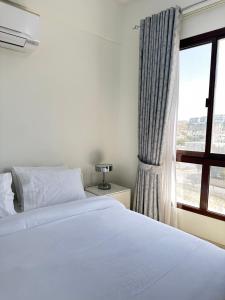 马斯喀特City Gem BAQ的卧室配有白色的床和窗户。