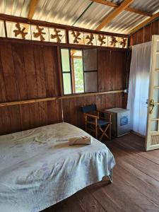 MesetasHostal La Cabaña的卧室配有床、桌子和窗户。