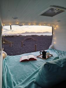 卡门港Camperita Van Life的一张位于帐篷内的床位,配有桌子和书