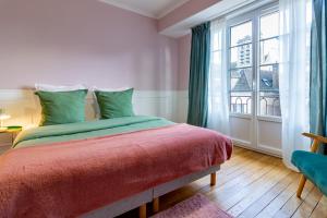 特鲁瓦Aux Deux Clochers de Troyes的一间卧室设有一张床和一个大窗户