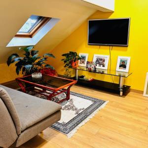 安纳马斯Elegancia del JJM的一间起居室,在黄色的墙上配有电视