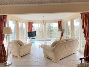 马尔洛Villa Recknitztal Marlow的客厅配有两把椅子和电视
