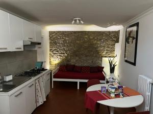 贝内文托Domus Isidis room camera singola con cucina的厨房以及带红色沙发的起居室。