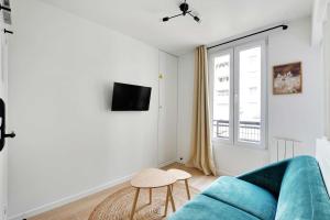 巴黎Small and modern apartment 11rd Paris的客厅设有蓝色的沙发和窗户。