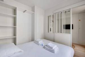 巴黎Small and modern apartment 11rd Paris的白色卧室,床上配有白色毛巾