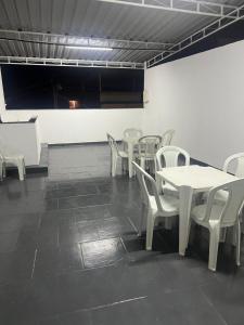 新伊瓜苏Suite 3, Casa Amarela, Terceiro Andar的用餐室配有白色的桌子和白色的椅子