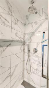 尼奥尔Votre Escale - Magellan Cinéma的一间设有白色大理石墙壁和淋浴的浴室