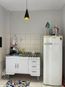 伊瓜苏Loft funcional no centro!的厨房配有炉灶和白色冰箱。