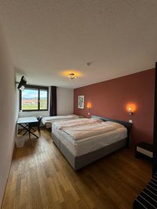 赛尼厄莱吉耶Jura Sport & Spa Resort的一间卧室设有两张床和窗户。
