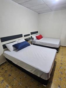 圣安娜Casa 25 hostal的白色和蓝色的客房内的两张床