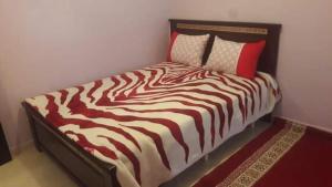 KetamaKetama كتامة的一张带红白条纹床单和枕头的床