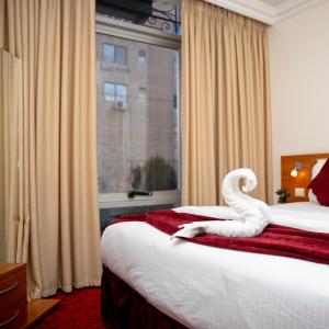 安曼Sama Paris Plaza Hotel的酒店客房设有两张床,上面有天鹅
