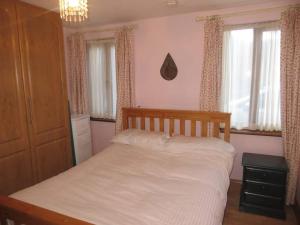 恩尼斯科西Borodino Studio Apartment的一间卧室配有一张带白色床单和窗户的床。