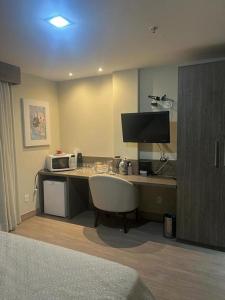 新伊瓜苏Alugo 1 Suite 210 no Mont Blanc的酒店客房配有带微波炉的书桌。