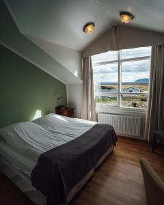 米湖赛尔-米瓦特酒店的一间卧室设有一张大床和一个大窗户
