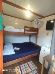 蜜岛Pousada Morada das Flores的一间小卧室,船上配有蓝色的床