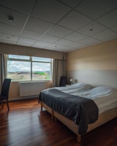 米湖赛尔-米瓦特酒店的一间卧室设有一张大床和一个大窗户