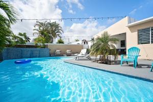 多拉多4 bedroom family reserve with pool home的一个带蓝色椅子的游泳池和一个房子