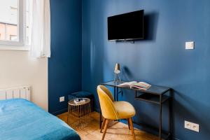 里昂Studios Part-Dieu Gare - HomaLyon的一间卧室设有蓝色的墙壁、一张床和一张书桌