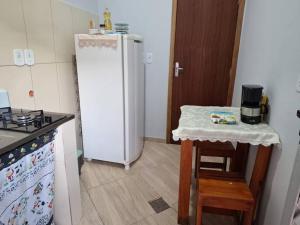 卡庞博尼图Edícula c/ wifi e banheiro externo em Capão Bonito的厨房配有白色冰箱和桌子