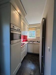 RixensartDuplex Rosières - 12’ de Bruxelles的厨房配有白色橱柜和炉灶烤箱。