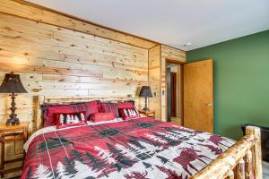 BigforkBigfork Cabin on Long Lake with Private Dock!的一间卧室设有一张带木墙的大床