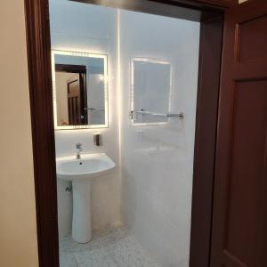 麦地那Khair Jewaar Apartments Al Madinah的白色的浴室设有水槽和镜子