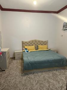 阿哈达شاليه قلب الهدا 3-4的一间卧室配有一张带绿毯和黄色枕头的床