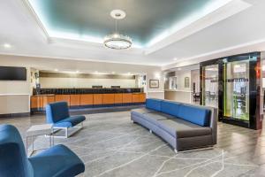 查尔斯顿Best Western Airport Inn & Suites的一间配备有蓝色沙发和椅子的等候室