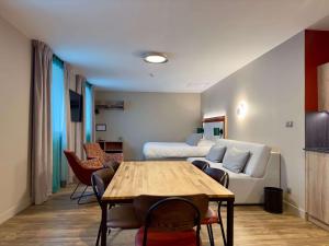 圣让德莫里耶讷Best Western Hotel Coeur de Maurienne的客厅配有沙发和桌子