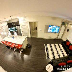 休斯顿Smart automation apartment in Woodlake/Westheimer的客厅配有桌子、沙发和电视。