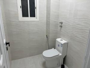 麦地那Almadina Laxury Apartemetns的一间带卫生间和窗户的小浴室