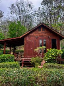 北标府Maingern Maithong Resort的花园内带门廊的小型小木屋