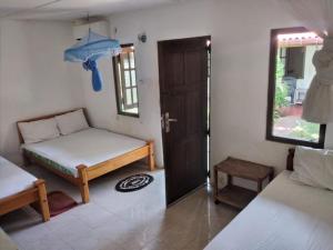 亭可马里Udayam guest的一间设有床铺和开放式门的房间